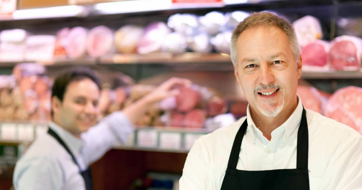 Slager staat in zijn winkel 